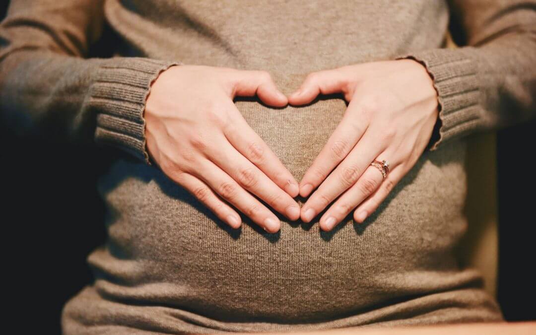 embarazada haciendo símbolo del corazón